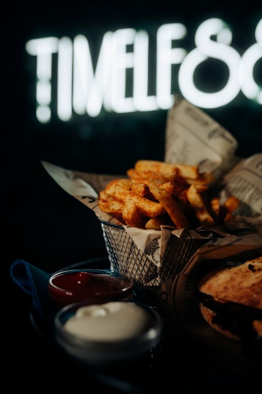 Pommes im Korb vor dem Neonschild