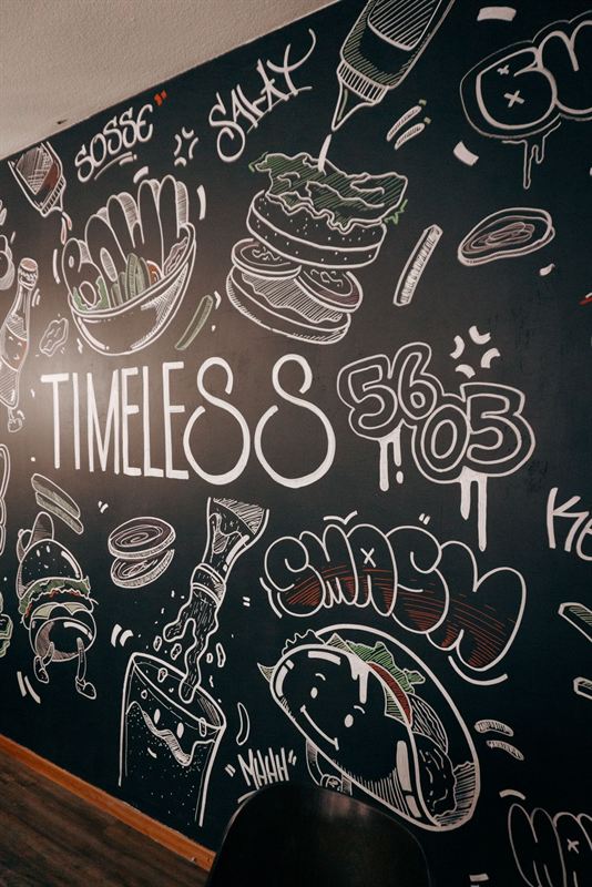 Kreidewand mit Timeless-Schriftzug und gezeichnetem Taco