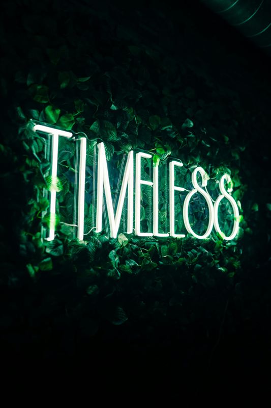 Timeless-Neonschild in der Pflanzenwand